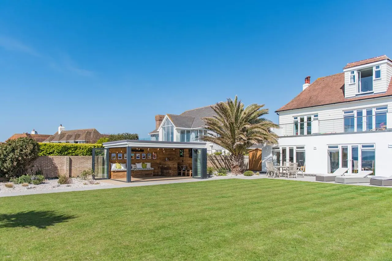 Sun Beach House seen from its lawn, with the sea behind